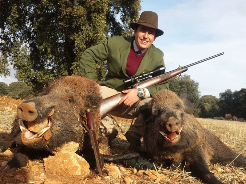 Hunter posing with wild boar after successful hunt in Spain
